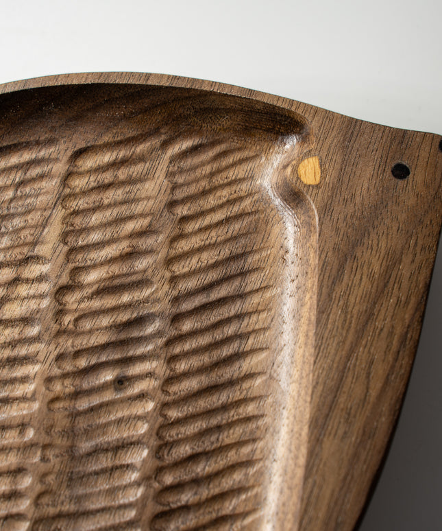 Close-up of hedgehog nose and eyes made with wood inlay on hand-carved walnut tray